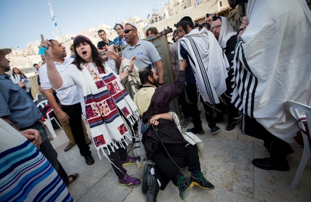 An orthodox man scuffles with a supporter of Women of the Wall, a group advocating for women's prayer at the Western Wall, April 20, 2015. (Miriam Alster/Flash90)