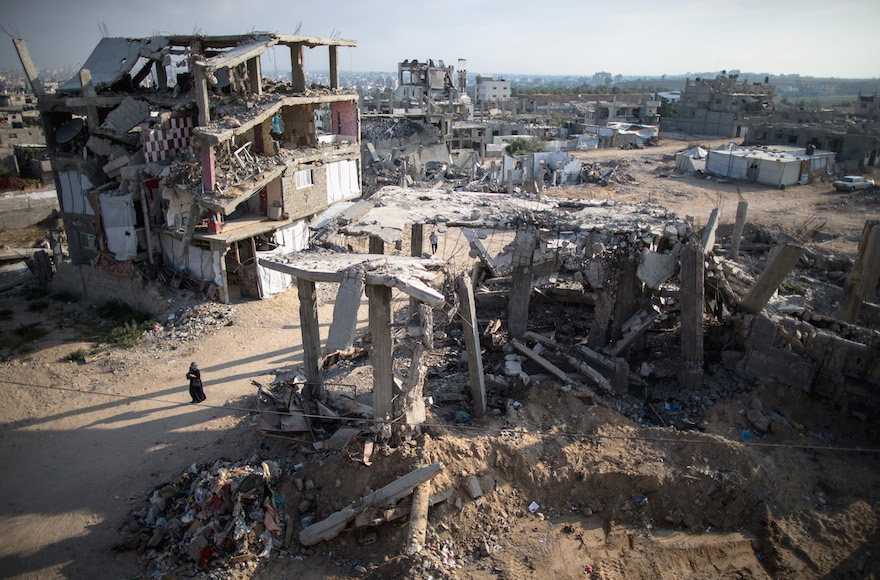 A Palestinian woman walks among the rubble from the 2014 Gaza war on June 14, 2014. (Christopher Furlong/Getty Images)
