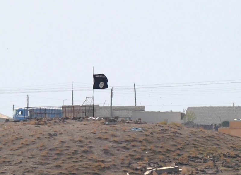 An Islamic State black flag flies near the Syrian town of Kobani, October 27, 2014. (Kutluhan Cucel/Getty Images)