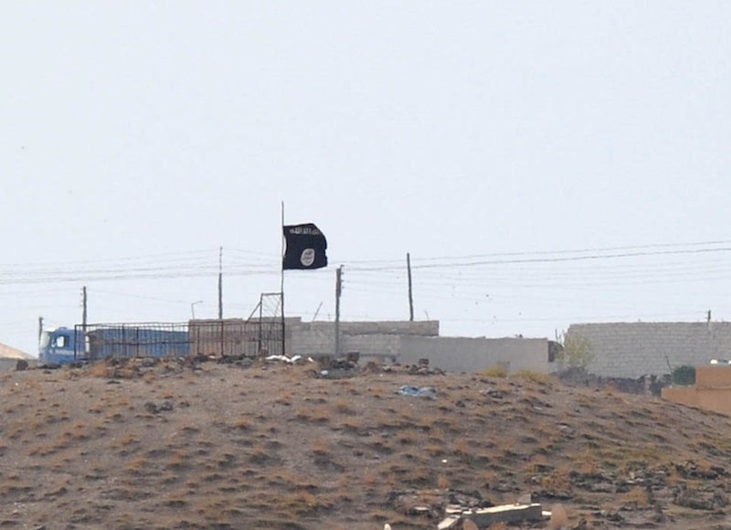 An Islamic State black flag flies near the Syrian town of Kobani, October 27, 2014. (Kutluhan Cucel/Getty Images)