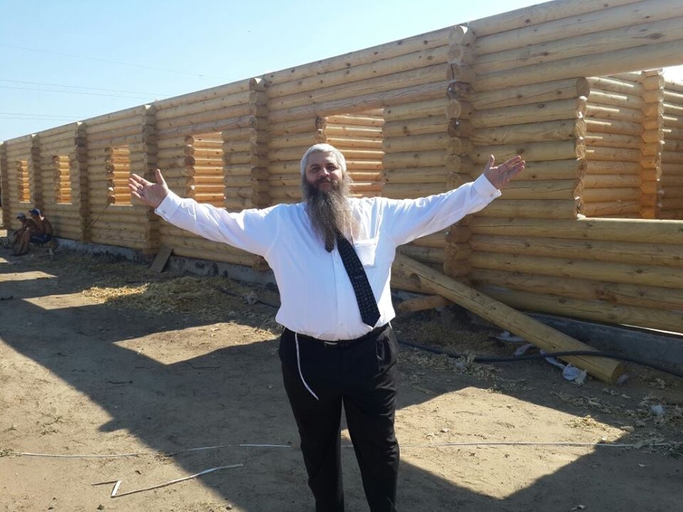 Rabbi Moshe Azman posing in front of houses under construction in Anatevka. (Courtesy: Anatevka)