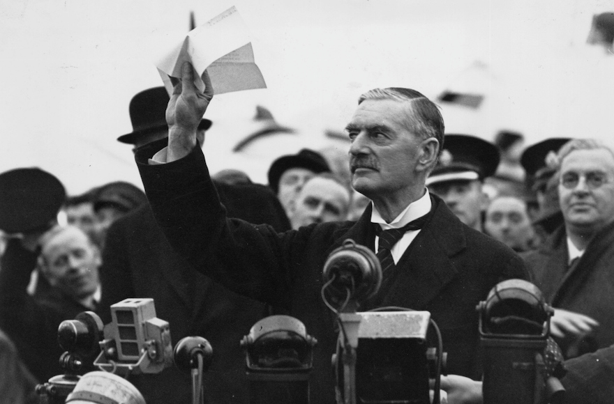 British statesman and Prime Minister Neville Chamberlain at Heston Airport on his return from Munich after meeting with Hitler, making his 