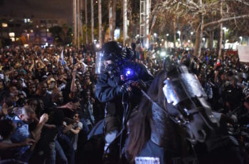 An Israeli policeman tries to disperse the hundreds of demonstrators in Tel Aviv protesting on behalf of Ethiopian-Israelis, May 3, 2015. (Ben Kelmer/Flash90)