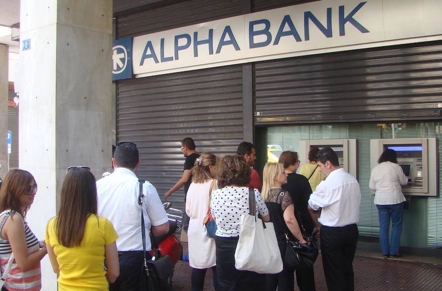 Greeks wait in line outside a shuttered bank to withdraw their daily allowance of 60 euros. (Gavin Rabinowitz)