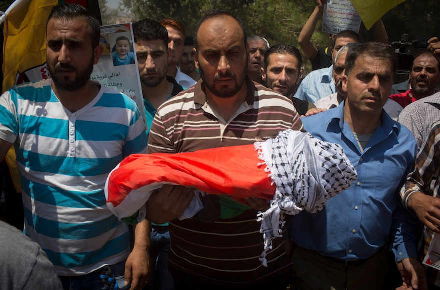 Surrounded by her relatives, the body of the 18-month-old baby Ali Saad-Dawabsheh is carried during her funeral in the Palestinian village of Duma, in the West Bank, on July 31, 2015. (Oren Ziv/Getty Images)