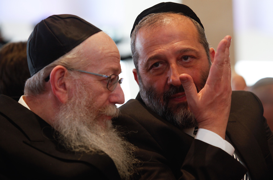 Shas party leader Aryeh Deri, right, speaks with United Torah Judaism leader Yaakov Litzman at the opening session of the 20th Knesset on March 31, 2015. (Nati Shohat/Flash90)