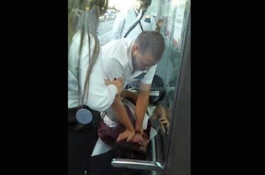 A Jerusalem light rail guard attacking an American tourist in a video that aired August 3, 2015, on Channel 10. (Screenshot:BrightCove)