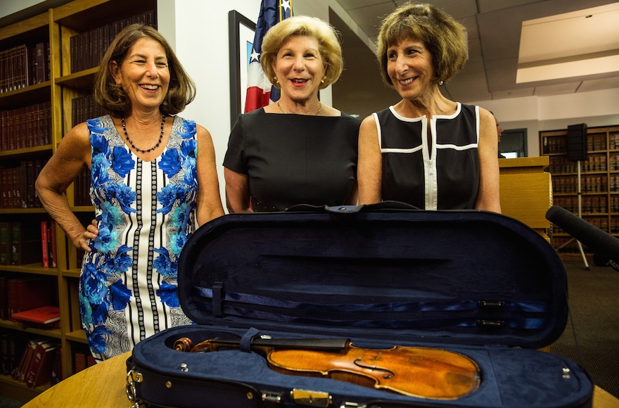 Jill Totenberg, Nina Totenberg and Amy Totenberg viewing their father's Stadivarius violin, which was stolen after a concert 35 years ago, at an FBI press conference announcing the recovery of the violin on Aug. 6, 2015, in New York. (Andrew Burton/Getty Images)