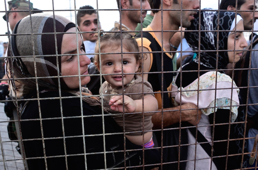 Migrants and refugees with temporary documents board a ferry to take them to Athens at the port of the Greek island of Kos on August 14, 2015. (Milos Bicanski/Getty Images)