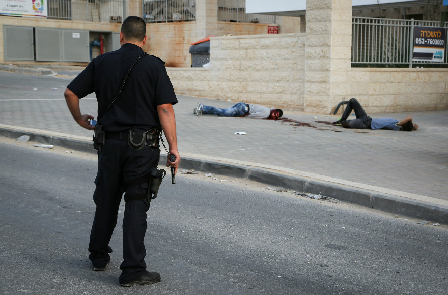 Israeli security guarding the two Palestinian assailants who were shot by police after attempting to carry out a stabbing attack in Beit Shemesh, on Oct. 22, 2015. (Yaakov Lederman/Flash90)