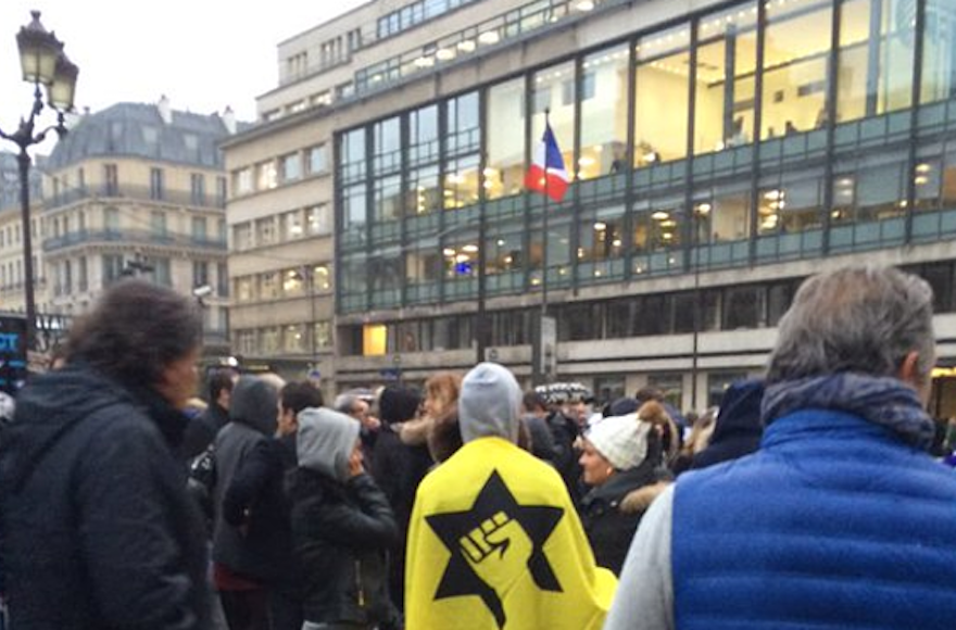Protest standing outside AFP’s offices in Paris, one displaying the Jewish Defense League flag. (Peter Allen/Twitter)