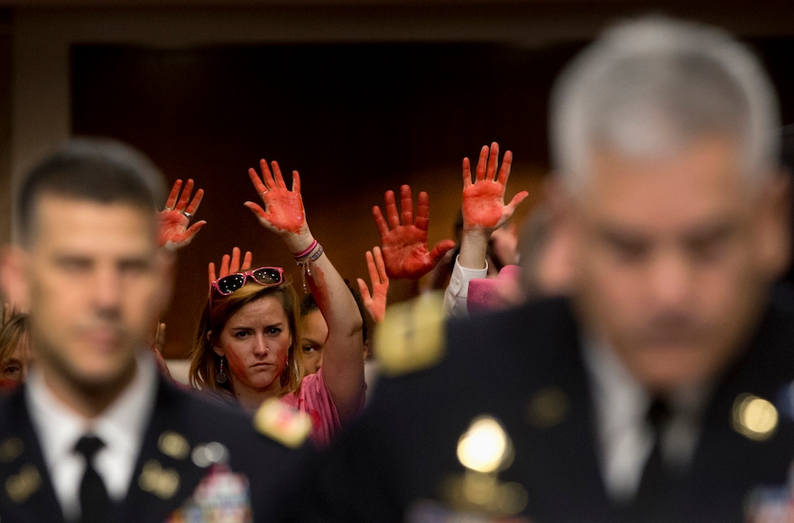 Members of CodePink protesting the deadly American attack on a hospital in northern Afghanistan as U.S. Forces-Afghanistan Resolute Support Mission Commander Gen. John Campbell, right, testifies on Capitol Hill in Washington, D.C., Oct. 6, 2015, before the Senate Armed Services Committee hearing on the Situation in Afghanistan. (Carolyn Kaster/AP Images)