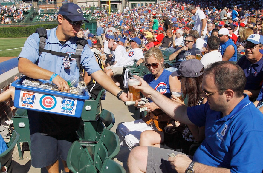 A vendor selling a beer to a fan during a Chicago Cubs baseball game at Wrigley Field in Chicago, Aug. 25, 2011. (Charles Rex Arbogast/AP Images)