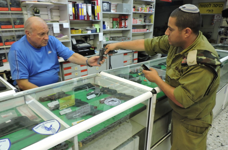 Itzhak Mizrahi, left, owner of a Jerusalem gun shop, says his business is booming. (Ben Sales)