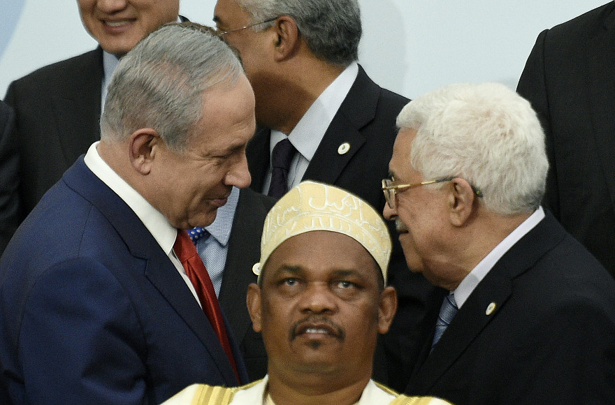 Israeli Prime Minister Benjamin Netanyahu shakes hands with Palesitnian Authority President Mahmoud Abbas following a group photo of world leades at the United Nations Climate Change Conference near Paris on Nov. 30, 2015. (AP Images photo by Martin Bureau)