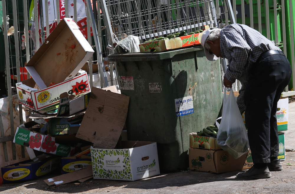 An Israeli man scavenging for food, June 24, 2015. Israel has among the highest food prices among advanced democracies, a recent study found. (Nati Shohat/FLASH90)