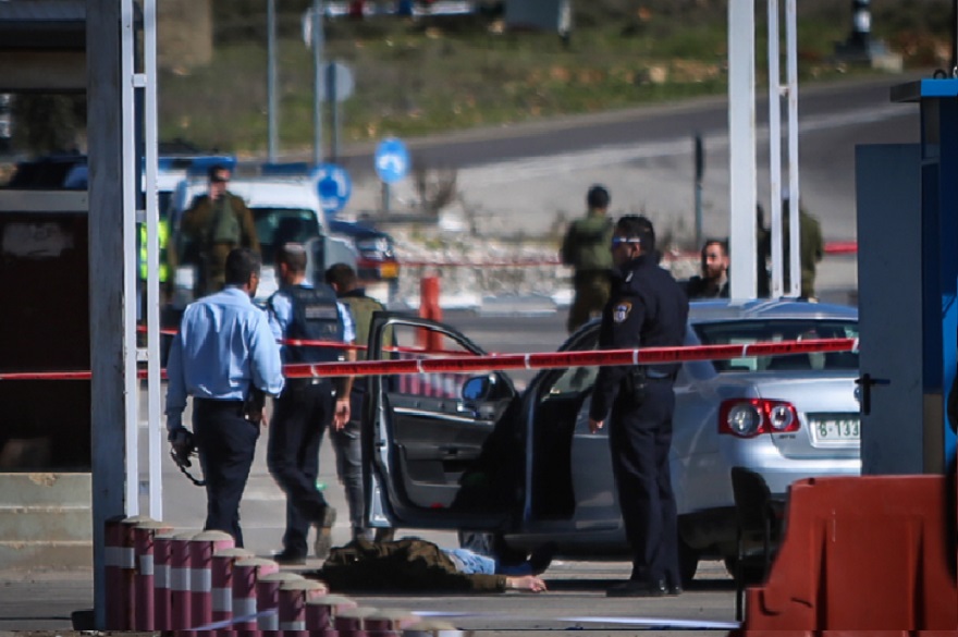 Israeli security forces standing by the body of a Palestinian attacker at the scene of shooting attack at a checkpoint near the Jewish settlement of Beit El in the West Bank before being shot dead, Jan. 31, 2016. (Flash 90) 