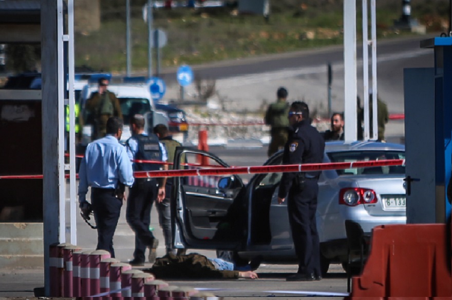 Israeli security forces standing by the body of a Palestinian attacker at the scene of shooting attack at a checkpoint near the Jewish settlement of Beit El in the West Bank before being shot dead, Jan. 31, 2016. (Flash 90)