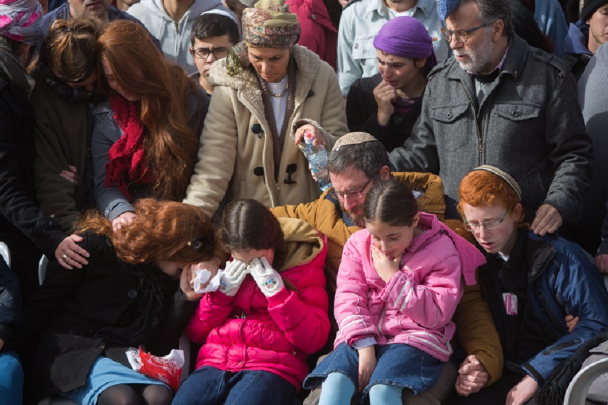 The husband and children of Dafna Meir grieving at her funeral in Jerusalem the day after her stabbing death in the West Bank, Jan. 18, 2016. (Yonatan Sindel/Flash 90)