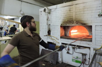 A man bakes matzah in a brick oven in Kfar Chabad. The small town provides ritual materials to Chabad emissaries across Israel. (Ben Sales)