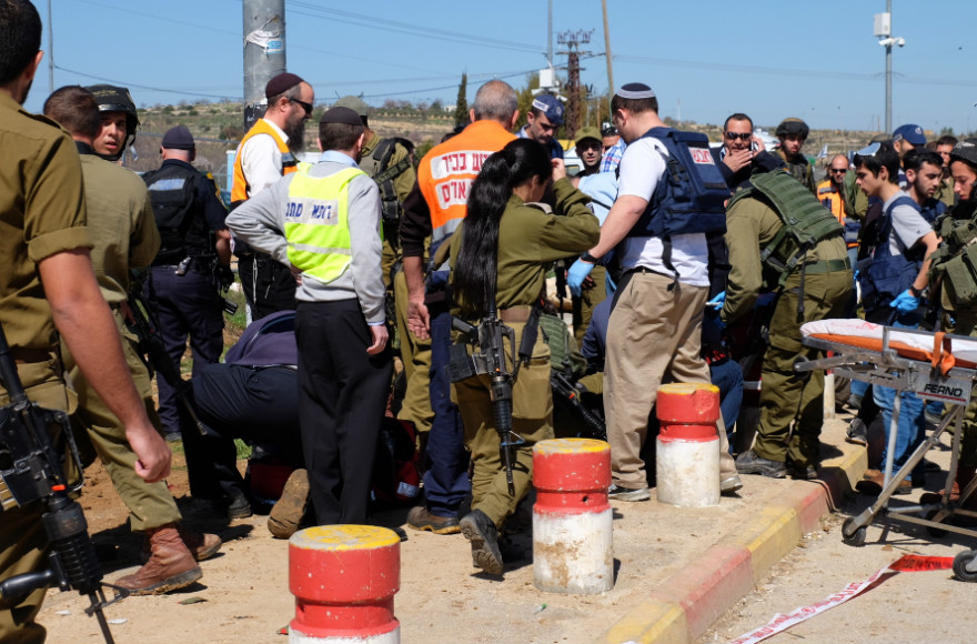 Israeli security forces and rescue personnel at the scene of a terror attack at Gush Etzion Junction, on Feb. 24, 2016. A 23-year-old Israeli man was critically injured by gunfire meant to stop a Palestinian assailant in a stabbing attack; the assailant also was hit. (Gershon Elinson/FLASH90)