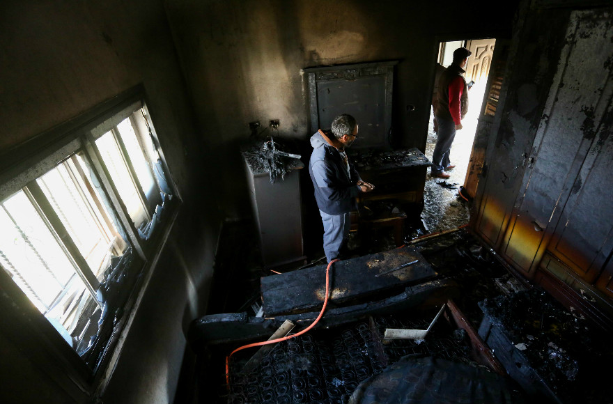 Local residents survey the inside of a burnt out house in the Palestinian village of Duma on March 20, 2016,beloning to the only witness to a July 2015 arson attack allegedly by Jewish extremists that killed three members of one family. (Photo/Flash90)