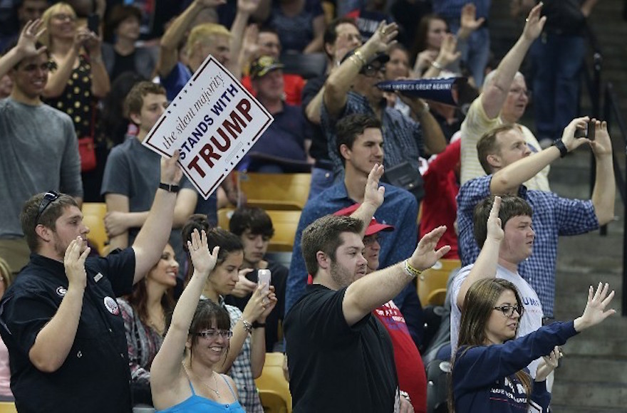 People raising their arms as Republican presidential candidate Donald Trump asks them to pledge that they will vote for him during a campaign rally at the CFE Arena on the campus of the University of Central Florida in Orlando, Florida, March 5, 2016. ( Joe Raedle/Getty Images/AFP)