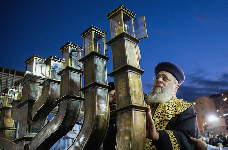 Rabbi of the Western Wall Shmuel Rabinovich taking part in lighting the Hanukkah candles on the large Menorah at the Western Wall, in the Old City of Jerusalem, Dec. 13, 2015. (Flash90)