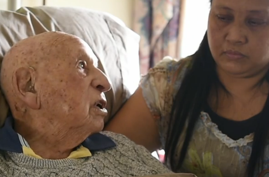 Holocaust survivor Richard Roberts being interviewed with his caregiver, Elenita Fernandez, in Sydney, Australian. (Screenshot)