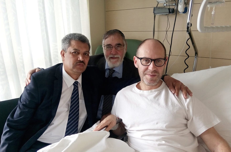 Walter Benjamin, right, being visited by Belgian Chief Rabbi Albert Guigui and Executive of Muslims in Belgium President Salah Echallaoui in a Brussels hospital, April 4, 2016. (Courtesy of Walter Benjamin)