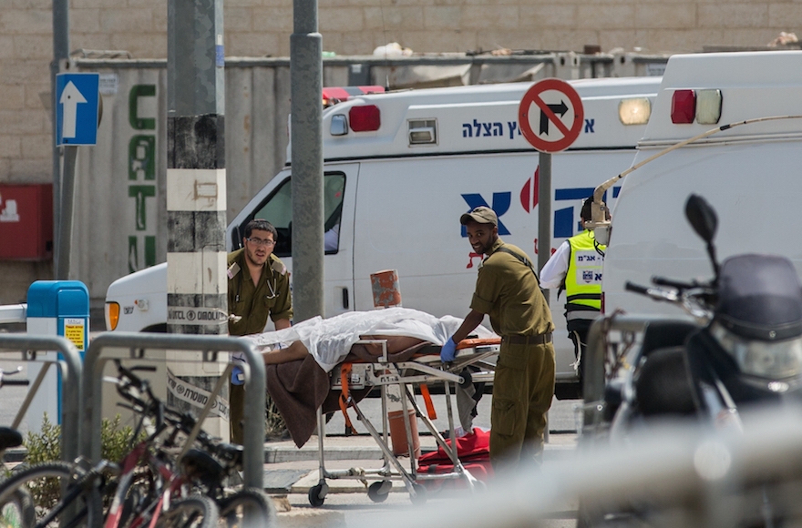 Israeli paramedics evacuating the body of a Palestinian man at the Qalandiya Checkpoint after an attempted stabbing attack, April 27, 2016. (Yonatan Sindel/Flash90)