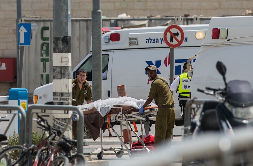 Israeli paramedics evacuating the body of a Palestinian man at the Qalandiya Checkpoint after an attempted stabbing attack, April 27, 2016. (Yonatan Sindel/Flash90)