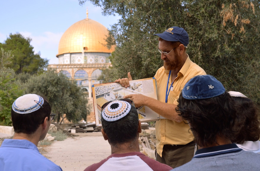 On a tour of the Temple Mount, Yehuda Glick shows religious Jews a diagram of the Jewish temple, which once stood where the golden Dome of the Rock stands today in Jerusalem, Sept. 17, 2013. (Christa Case Bryant/The Christian Science Monitor/Getty Images)