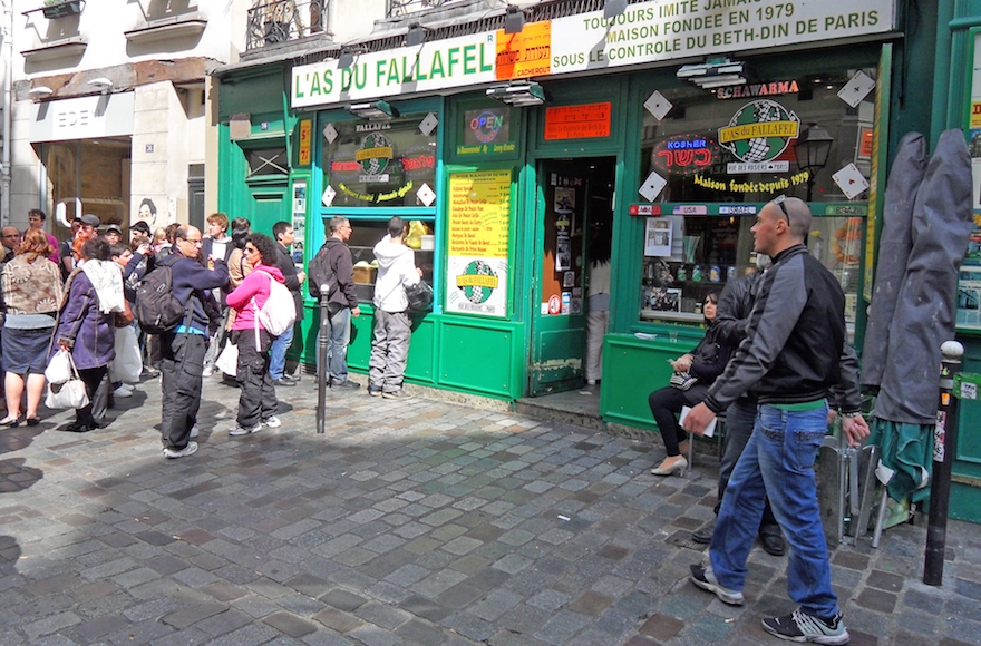 Yomi Peretz, right, approaching a line of tourists waiting to place their order at L'As Du Fallafel in Paris's historic Jewish quarter in April 2012. (WikiMedia Commons) 