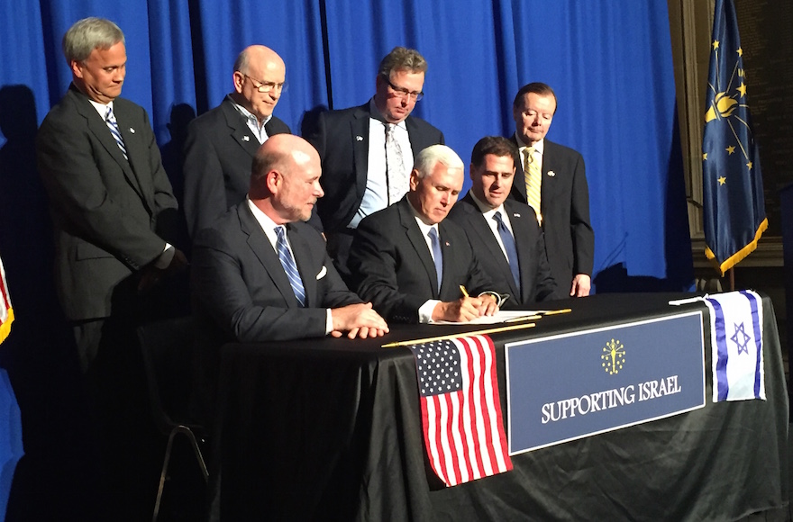 Indiana Gov. Mike Pence joined by Israeli Ambassador to the United States Ron Dermer, second from right, as he ceremonially signed legislation requiring the state to divest from any business that engages in action to boycott, divest or sanction the state of Israel, May 27, 2016. (Screenshot from Twitter)