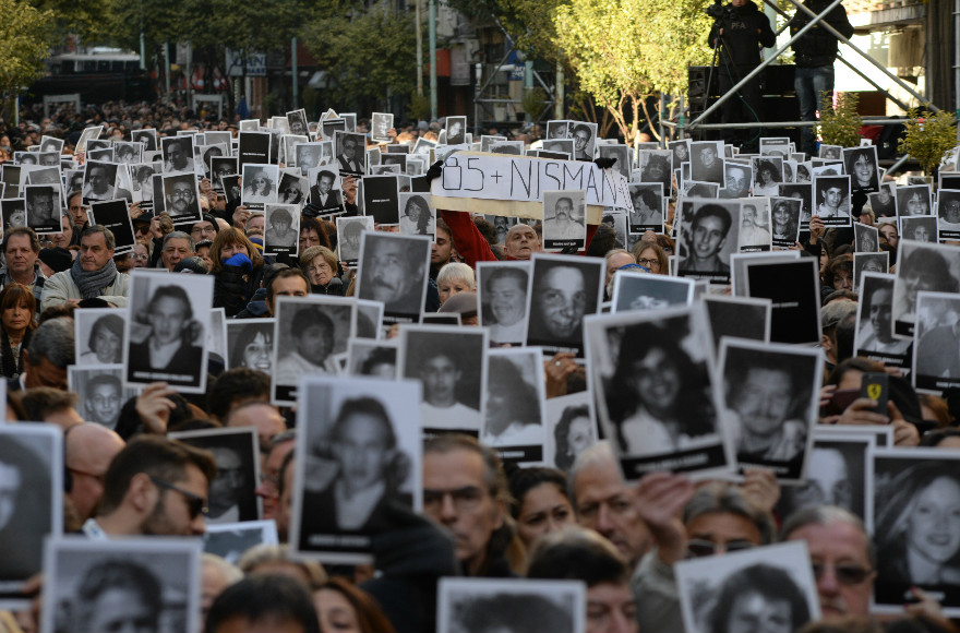 Participants in a memorial ceremony on the 22nd anniversary of the AMIA Jewish Center bombing in Buenos Aires hold photos of some of the 85 victims on July 18, 2016. (Photo by Leonardo Kremenchuzky courtesy of AMIA) 