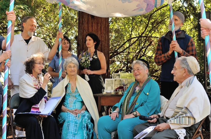 At 76, longtime activists Shoshana Dembitz, seated, center left, and Abigail Grafton, seated, center right, married in El Cerrito, Calif., on June 27. The ceremony was officiated by Rabbi Diane Elliot, seated left, and her husband, Rabbi Burt Jacobson. (Lea Delson)