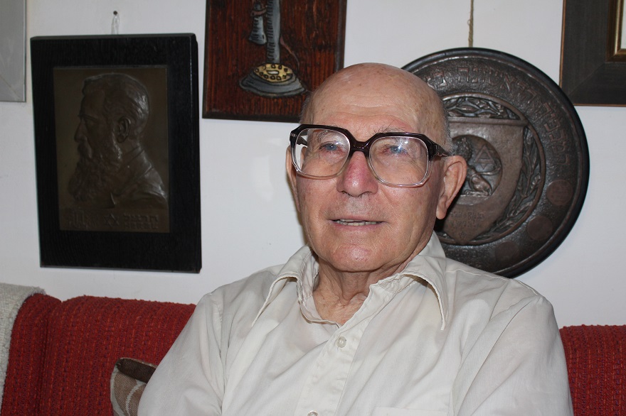 Shaul Ladany in his home near Beersheba with a prized piece of his Theodor Herzl collection, left. (Hillel Kuttler)