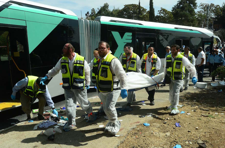 Orthodox ZAKA volunteers clean up the scene of a bus attack in Jerusalem, Israel, on Oct. 13, 2015. (Kobi Gideon/Israeli Government Press Office via Getty Images)