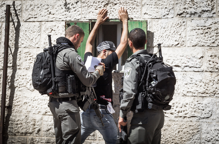 An Israeli border police officer checking a Palestinian man in front of Damascus Gate in Jerusalem's Old City, Sept. 20, 2016. (Sebi Berens/Flash90)