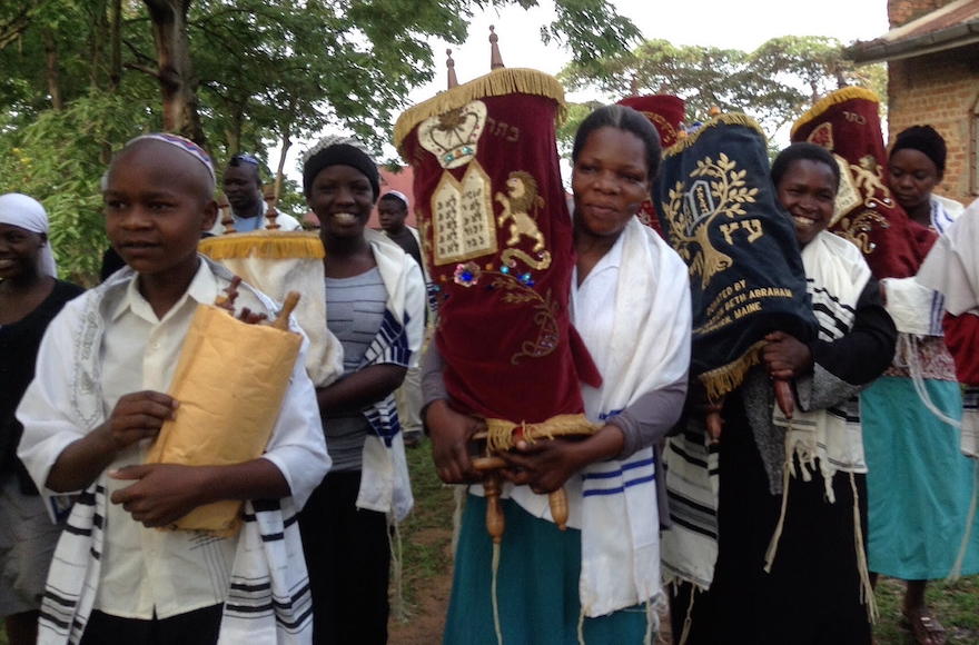 In anticipation of the construction of a new synagogue in Nabagoye, Uganda, the women and children were given the honor of transferring the Torahs from the old synagogue to a temporary home. (Courtesy of Be'chol Lashon) 