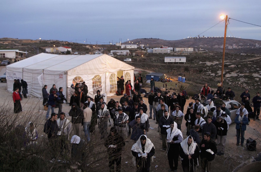 Israeli settlers praying in the West Bank settlement of Amona, Feb. 1, 2006. (Uriel Sinai/Getty Images)