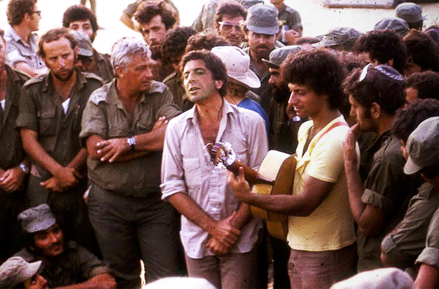 Leonard Cohen, center, performing with Mati Caspi, on guitar, for Ariel Sharon and other Israeli troops in Sinai in 1973. (Courtesy of Ma'ariv)