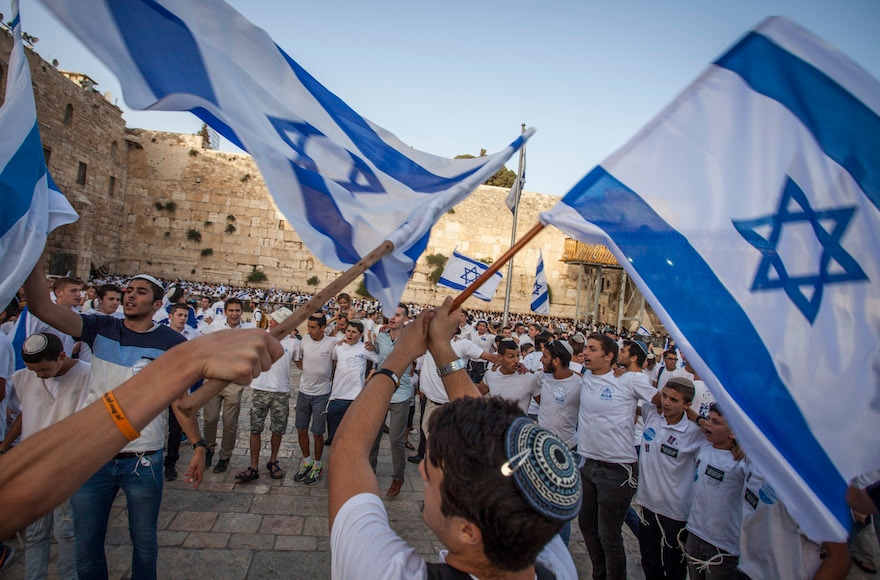 Jewish boys waving the Israeli flag in front of the Western Wall in the Old City of Jerusalem as part of celebrations for Jerusalem Day, June 5, 2016. (Zack Wajsgras/Flash90