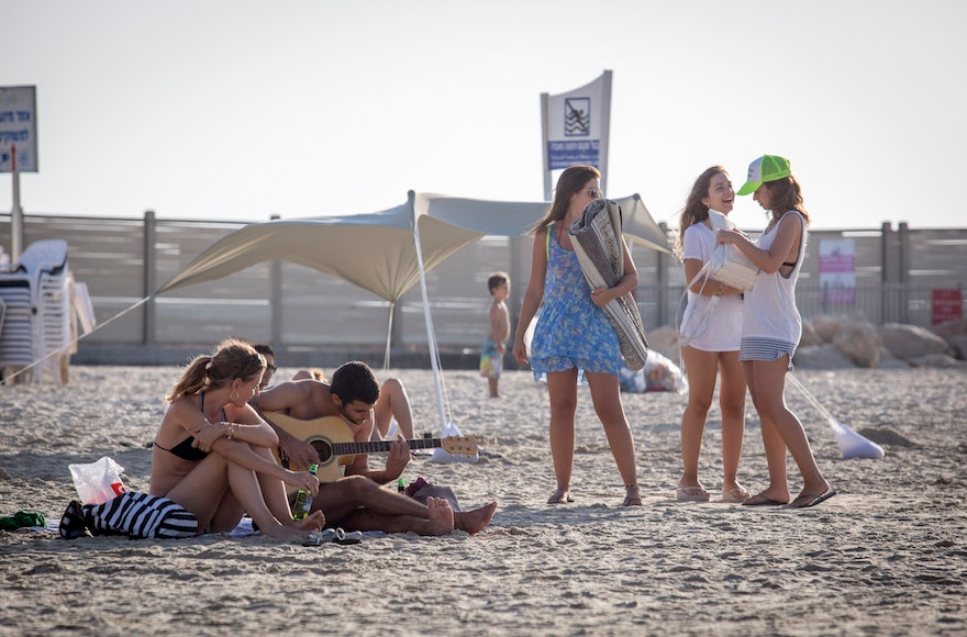 Israelis enjoying the warm weather on the beach in Tel Aviv, Oct. 3, 2016. (Nati Shohat/Flash90)