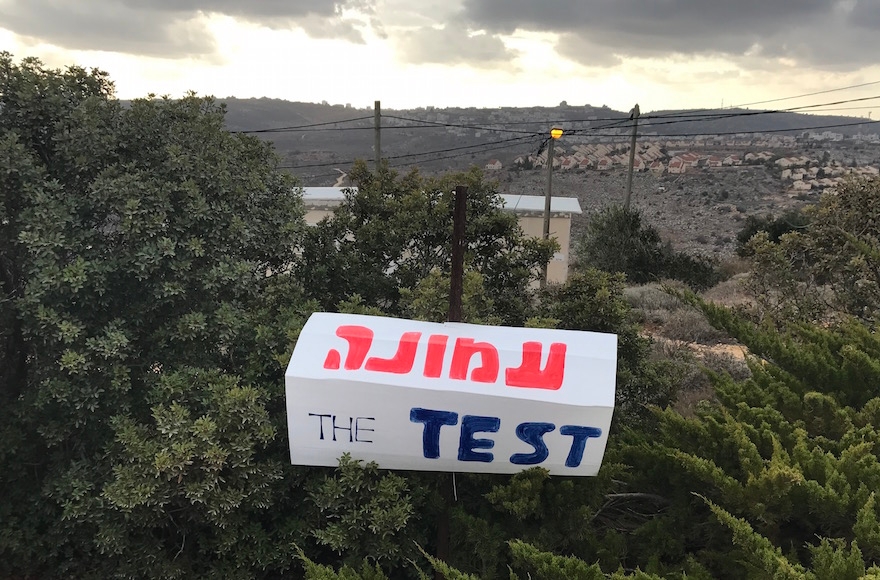 A sign saying "Amona: The Test" in Amona, the West Bank, Dec. 13, 2016. (Andrew Tobin)