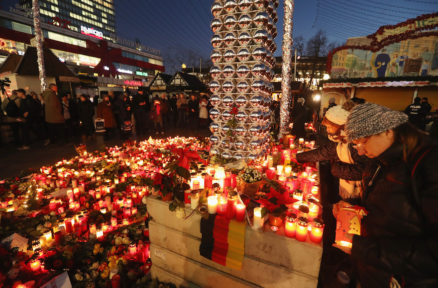 Mourners laying flowers and candles at a makeshift memorial near the site where two days before a man drove a heavy truck into a Christmas market in an apparent terrorist attack in Berlin, Germany, Dec. 21, 2016. (Sean Gallup/Getty Images)