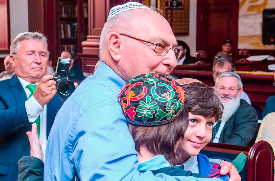 Ephraim Lapid hugging the children of Yanush Ben Gal in Kazan, Sept. 4, 2016. (Limmud FSU)