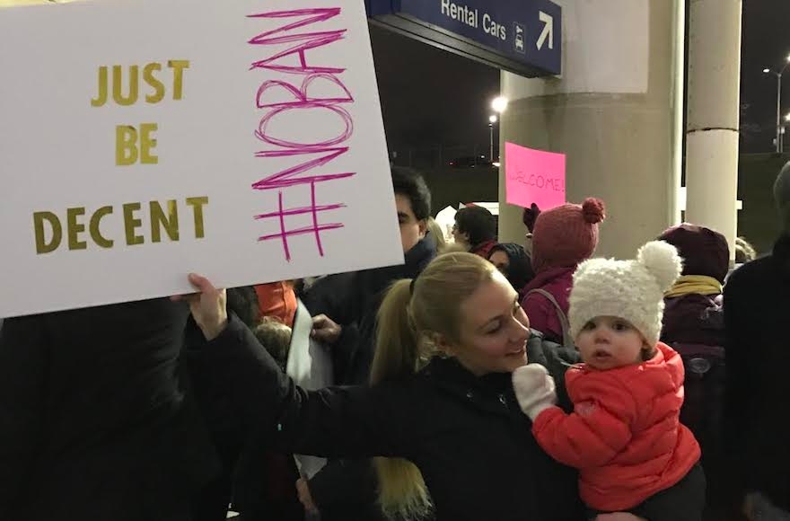 Taylor Clearfield holding a sign, and her daughter, at a protest of the refugee ban at O'Hare International Airport in Chicago, Jan. 27, 2017. (Courtesy of Taylor Clearfield)