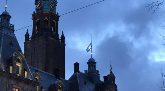 The Israeli flag flying at half-mast atop City Hall in rotterdam, the Netherlands, on Jan. 10, 2017. (Photo courtesy of NIW/David de Leeuw)